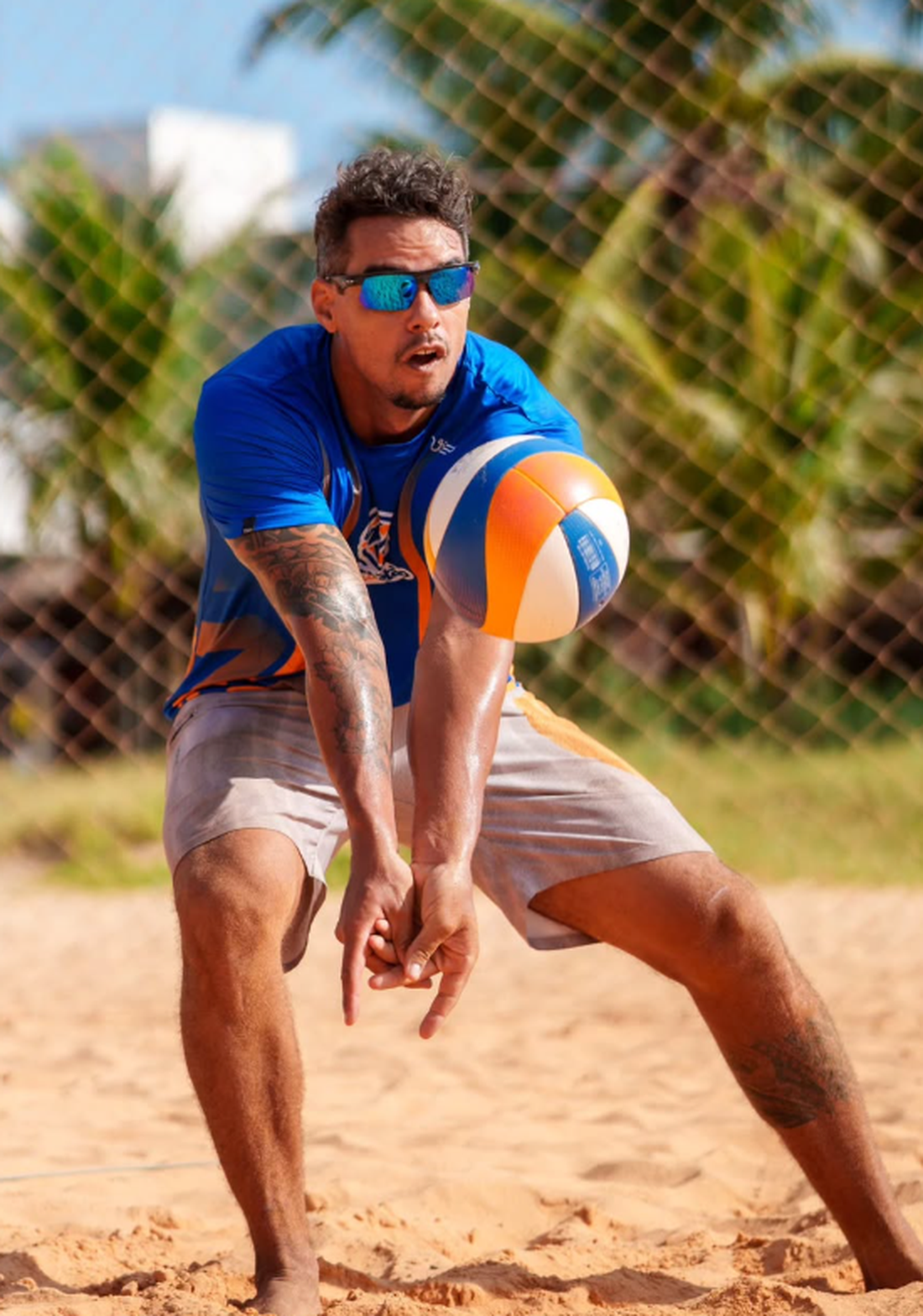 Bruno fazendo uma manchete na quadra de vôlei de praia